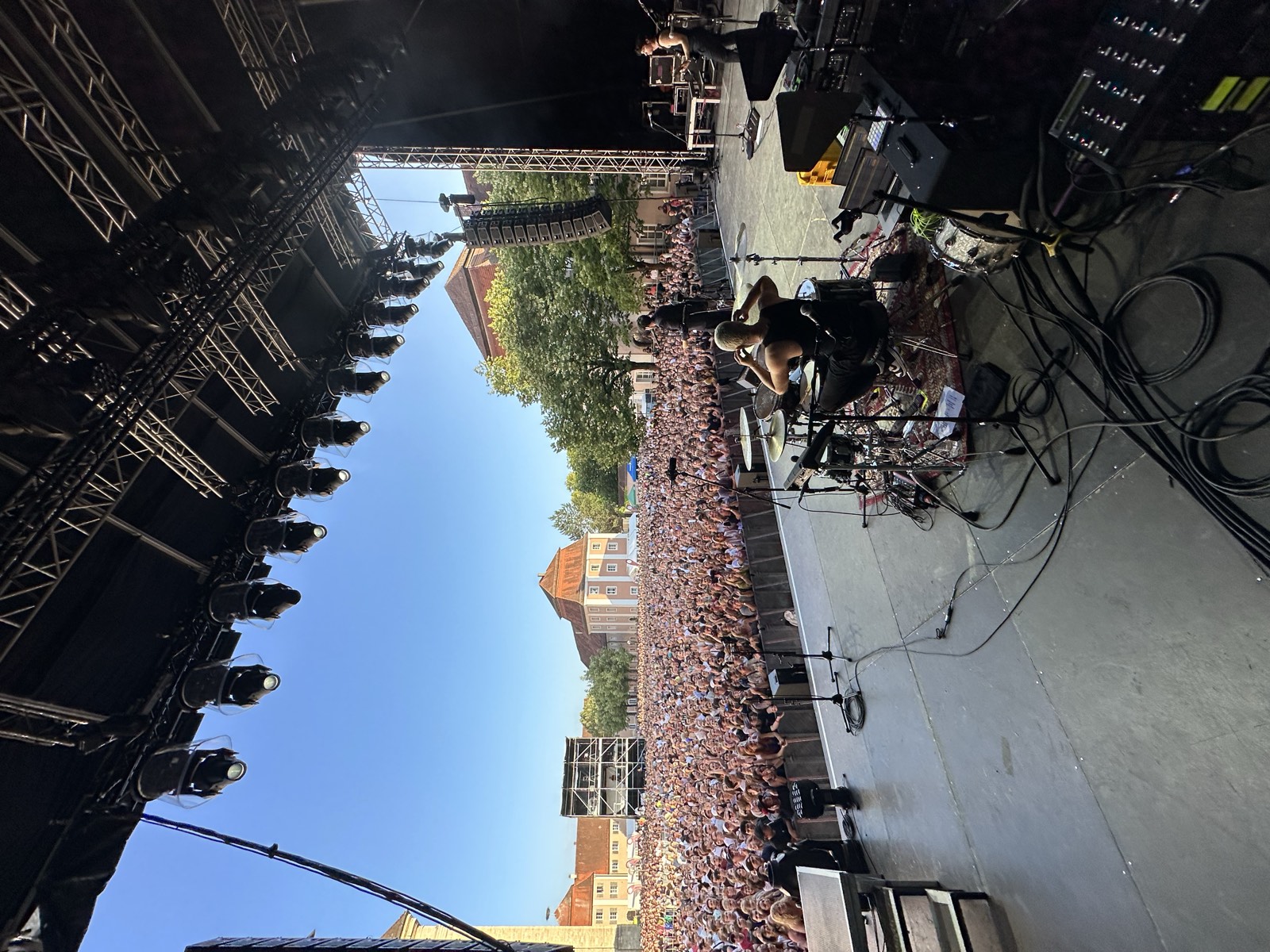 Daytime festival stage in front of a packed field